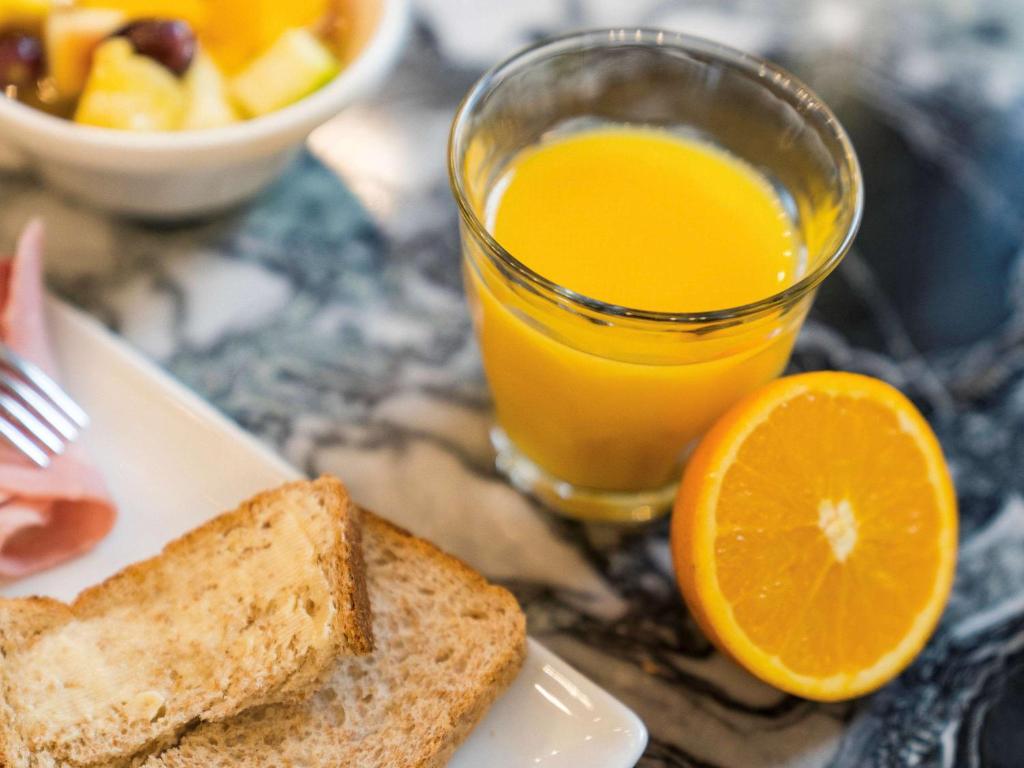 a plate with toast and a glass of orange juice at ibis Styles Paris Nation Cours de Vincennes in Paris
