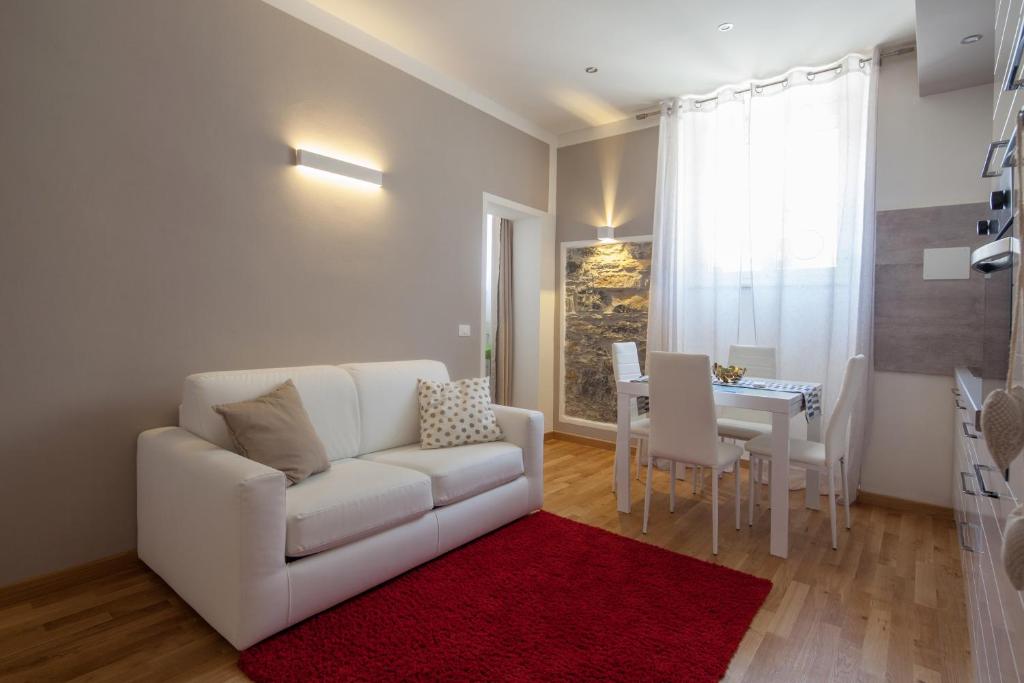 ein Wohnzimmer mit einer weißen Couch und einem roten Teppich in der Unterkunft LEO'S HOME in La Spezia