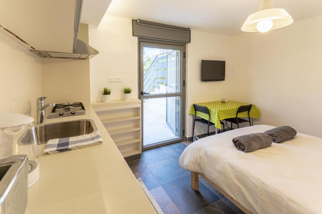 cocina con cama y mesa en una habitación en Quiet Apartments in Beit Safafa- Jerusalem, en Jerusalén