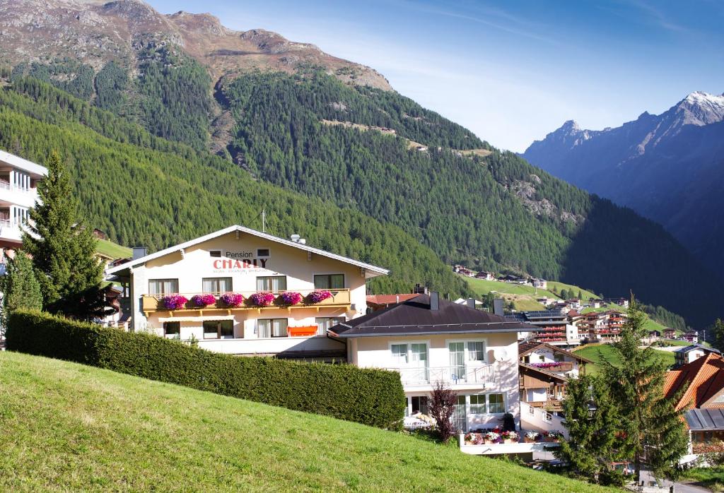 una ciudad en una colina con montañas en el fondo en Pension Charly, en Sölden