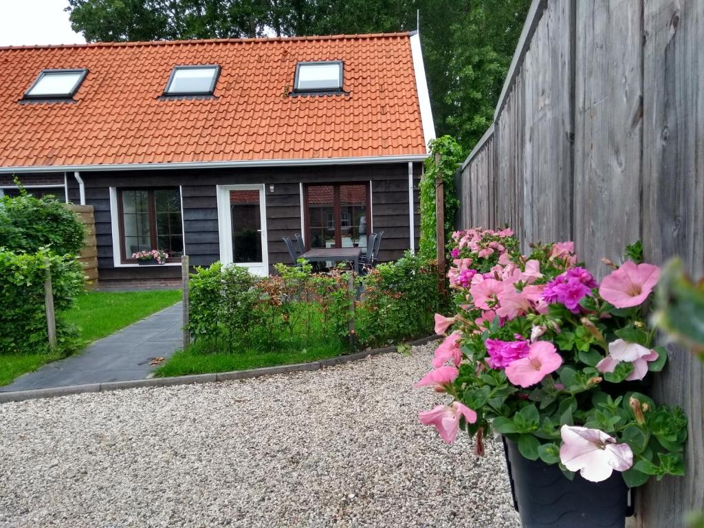 una casa con una valla y flores delante de ella en Veers Vertier, en Veere