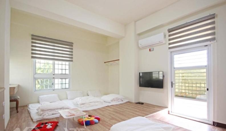 a living room with two beds and a flat screen tv at Chuan Men Zih in Tainan