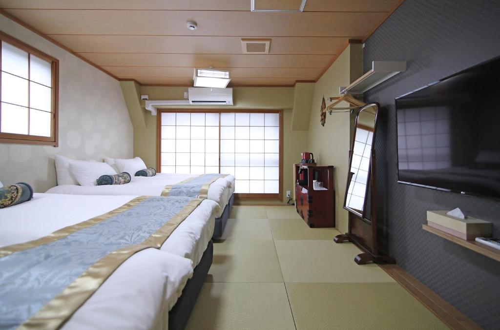東京にあるSHINJUKU GLOBAL HOTELのベッド2台、薄型テレビが備わる客室です。