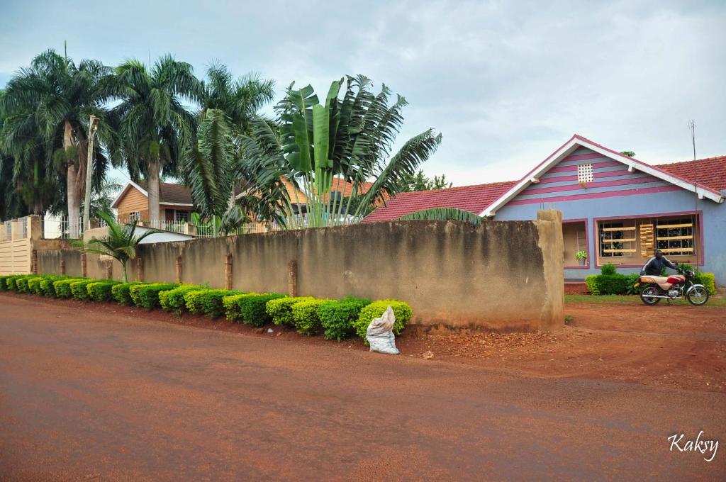 a person is sitting on the side of a street at Venchester Guest House in Jinja