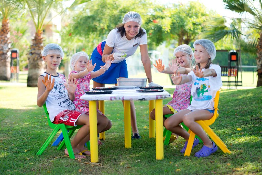 a group of little girls sitting around a table at Limak Arcadia Sport Resort Belek in Belek