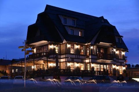 a large building with lights in front of it at Hotel Zlatni Bor in Sokolac