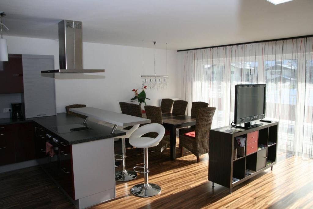 cocina y sala de estar con mesa y TV en Appartement Crystal by Schladmingurlaub, en Schladming