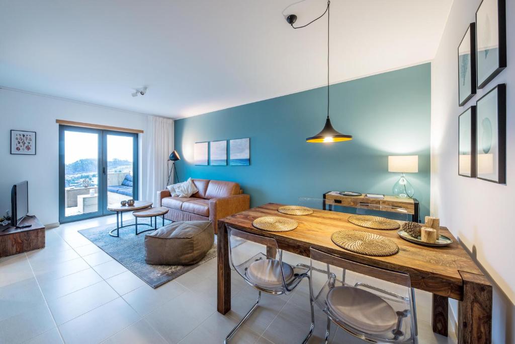 a living room with a wooden table and blue walls at maresoul - Ferienapartment mar in Raposeira