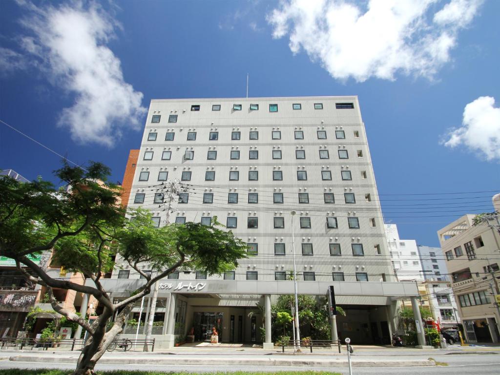 - un bâtiment blanc dans une rue de la ville dans l'établissement Hotel Route-Inn Naha Asahibashi Eki Higashi, à Naha
