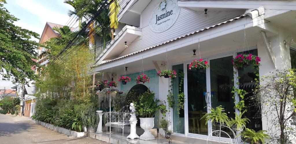 a white building with flowers in the window at Jasmine Chiangmai Boutique Hotel in Chiang Mai