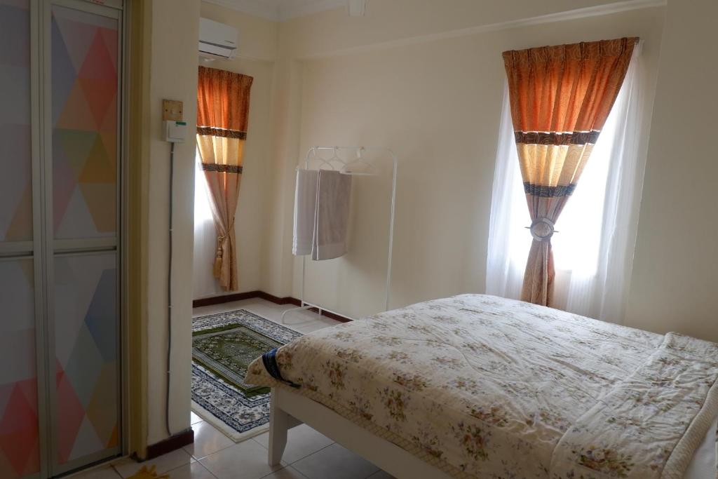 a bedroom with a bed and a window at Permai Seri Homestay in Ampang
