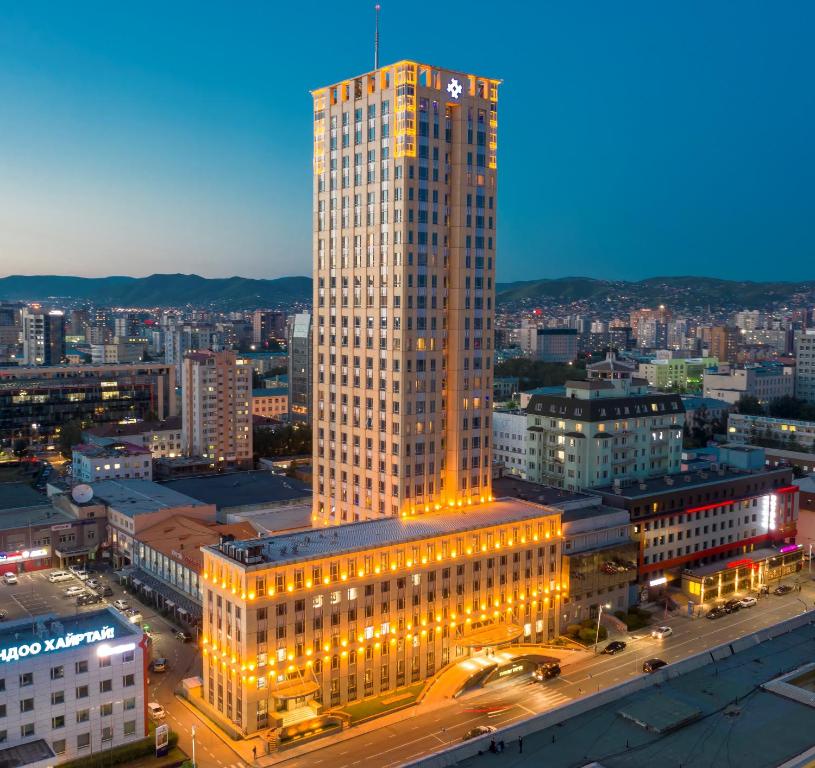 ein beleuchtetes Gebäude in einer Stadt in der Nacht in der Unterkunft Best Western Premier Tuushin Hotel in Ulaanbaatar