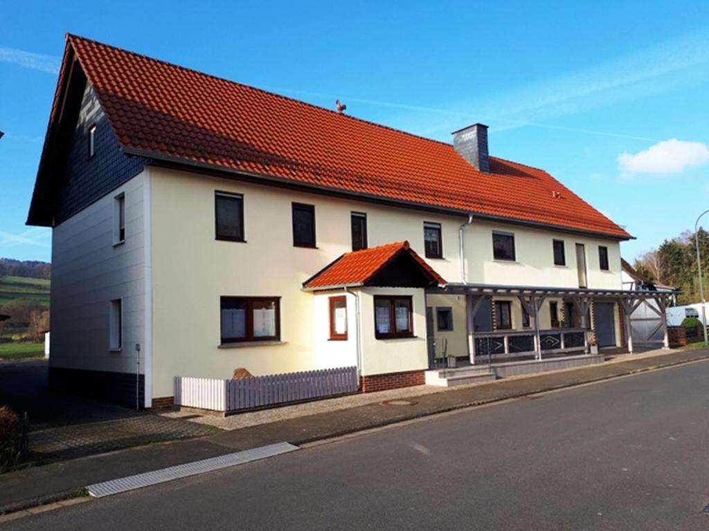 una casa blanca con techo naranja en una calle en Ferienwohnung Schäfer en Steinau an der Straße