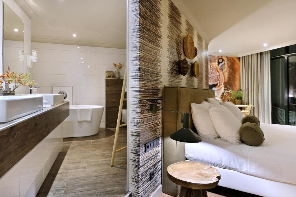 een badkamer met een bed, een wastafel en een bad bij Van der Valk Theaterhotel Almelo in Almelo