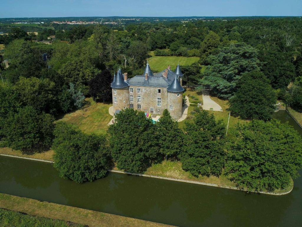 een luchtzicht op een kasteel op een eiland in het water bij Château De La Frogerie in Maulévrier
