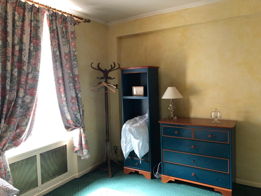a bedroom with a blue dresser and a window at LE CABOUILLET in LʼIsle-Adam