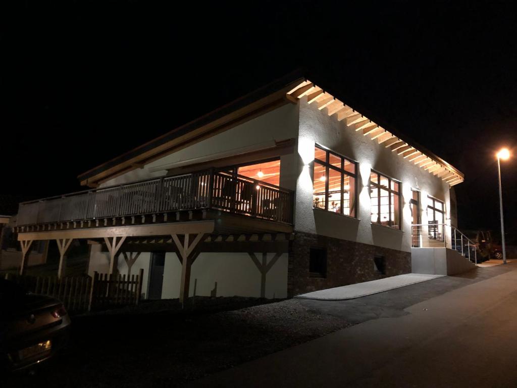 a building with a porch and balcony at night at Carolinger Hüttendorf in Weyer