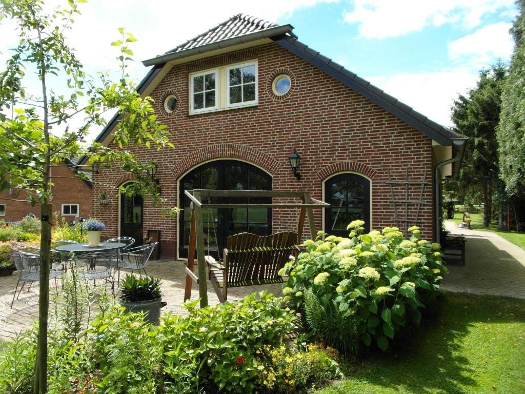 a brick house with a table and chairs in a garden at Spacious holiday farm in Bronckhorst with private garden in Bronkhorst