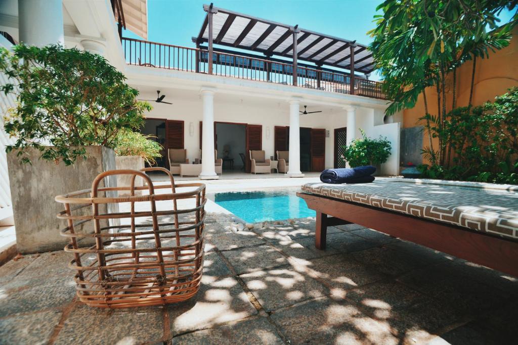 a pool with a bench in front of a house at 32 Middle Street - 03 Bedrooms villa with private pool in Galle