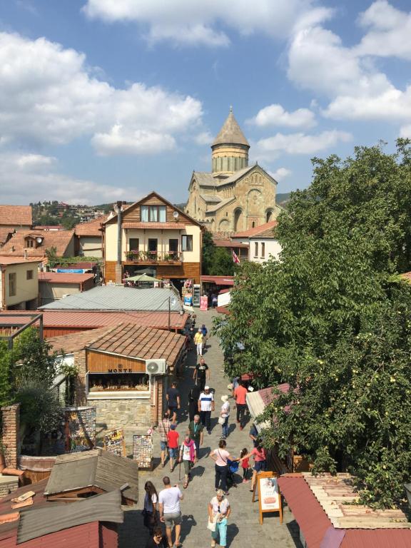 a group of people walking down a street in a town at Mtskheta Wellpoint Arsukidze 48 in Mtskheta