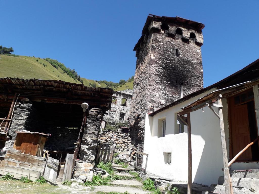 an old building with a tower in a village at Hotel Family Bachi in Adishi