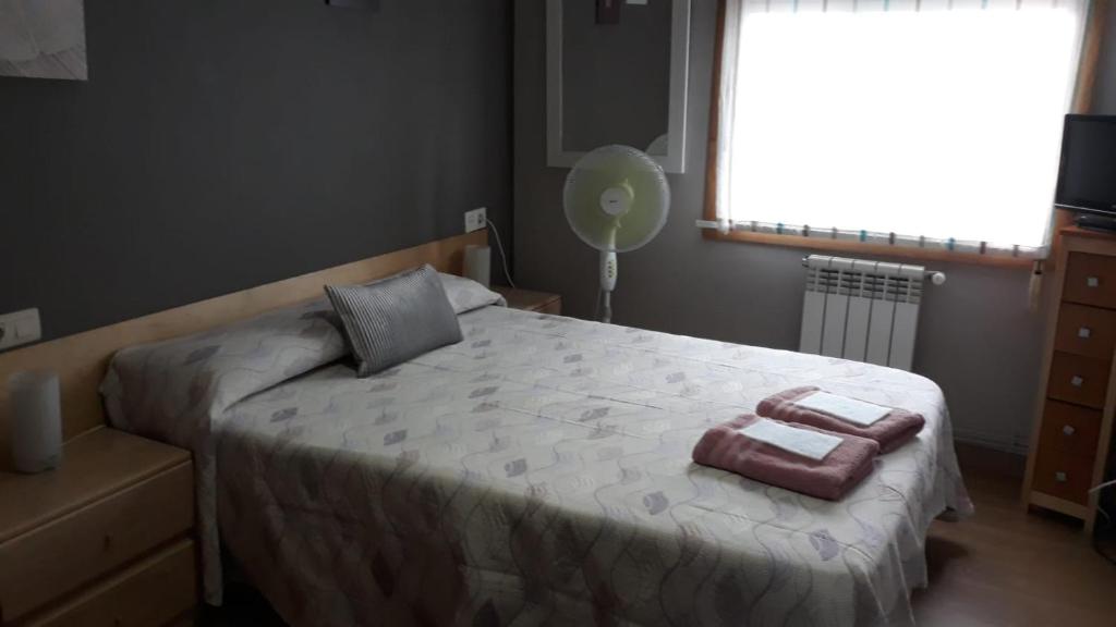 una camera da letto con un letto e due asciugamani di Apartamento SIGÜEIRO CAMINO INGLÉS (English Way) a Sigüeiro