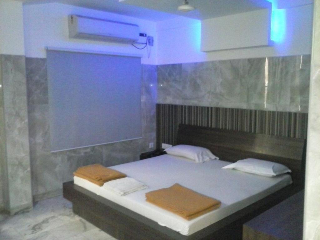 een slaapkamer met een bed met een blauw licht bij Hotel Joyce in Chennai