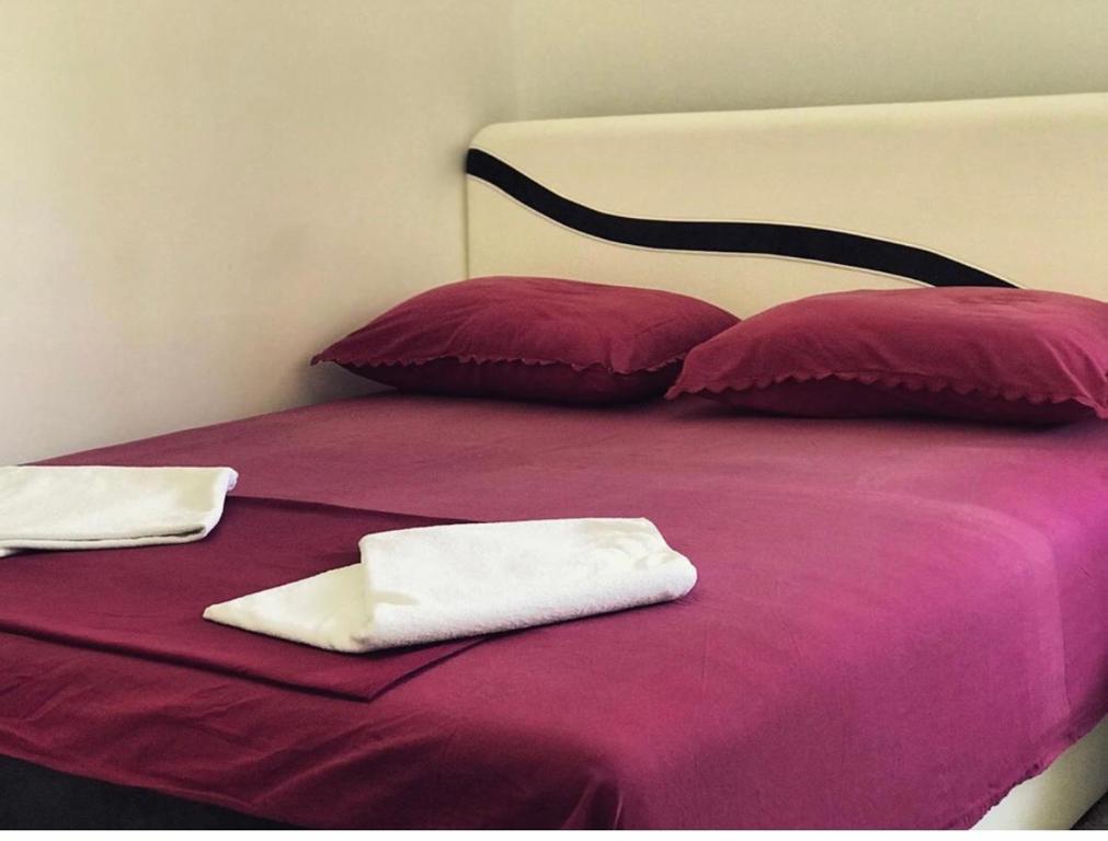 een bed met twee handdoeken bovenop bij Laguna apartment in Tivat