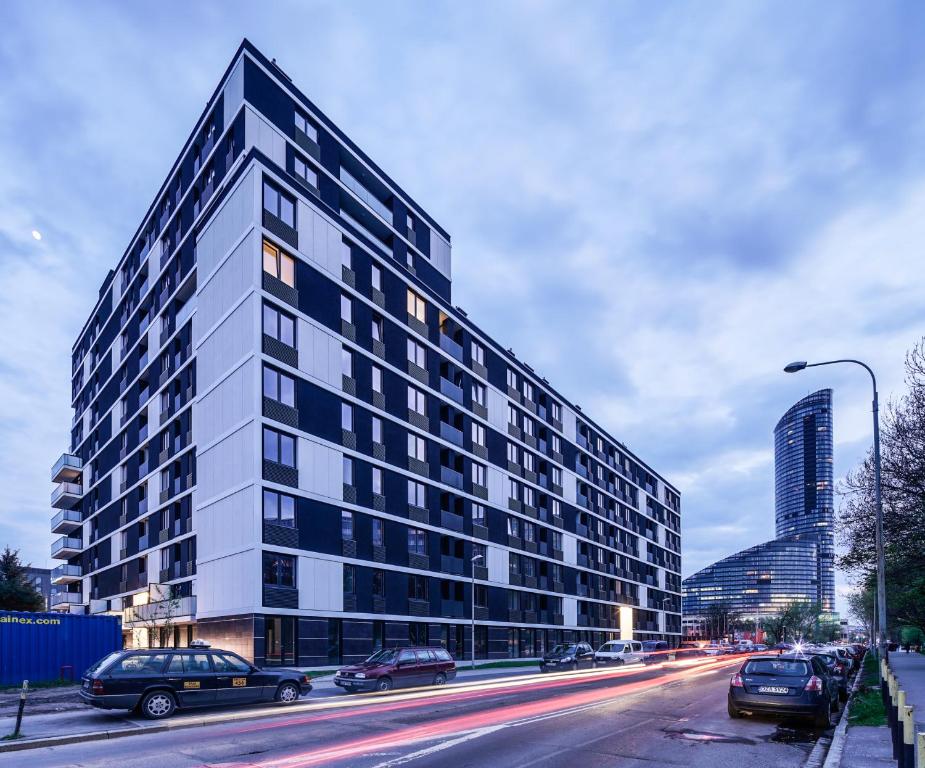 un edificio alto con coches estacionados frente a una calle en Star4You Apartments en Breslavia