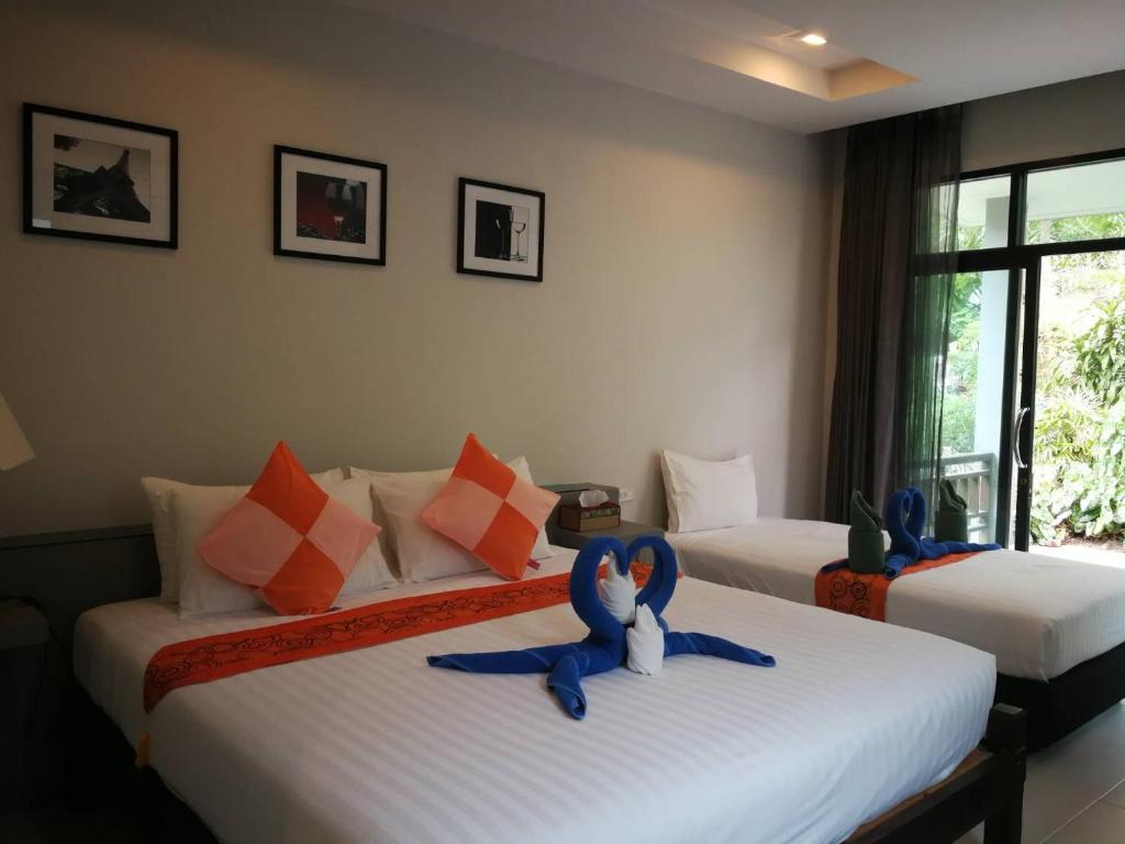 - deux lits dans une chambre d'hôtel avec des animaux rembourrés dans l'établissement Sun Moon Star Resort Koh Phangan, à Haad Yao