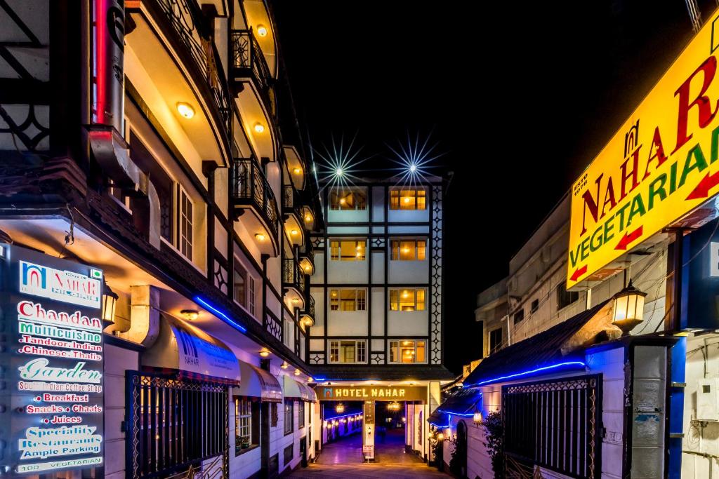 a city street at night with buildings and signs at Hotel Nahar Nilgiris in Ooty