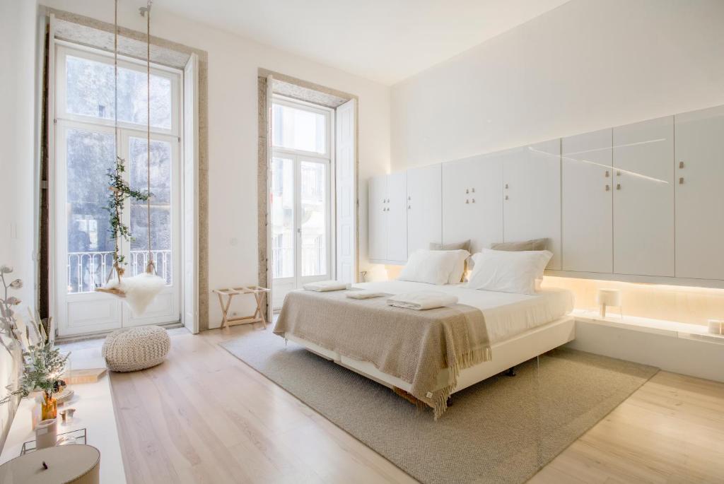 um quarto branco com uma cama grande e uma banheira em OHH - Mouzinho Deluxe Apartment em Porto