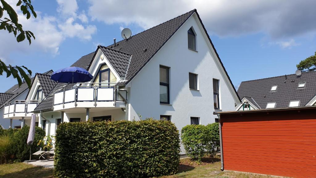ein weißes Haus mit einer roten Garage in der Unterkunft Meeresbrise Asternweg in Zinnowitz