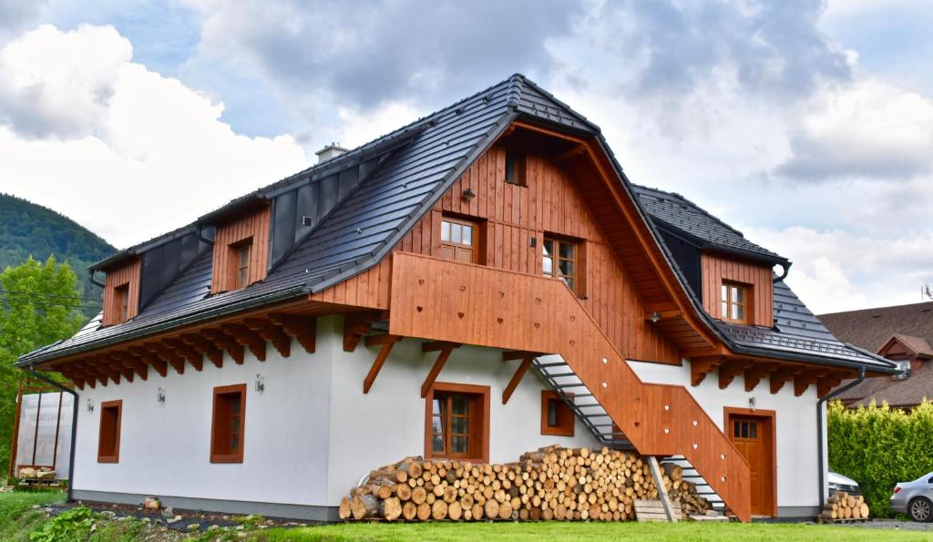une maison en bois avec un toit en gambrel dans l'établissement Penzion Beskydkrby, à Ostravice