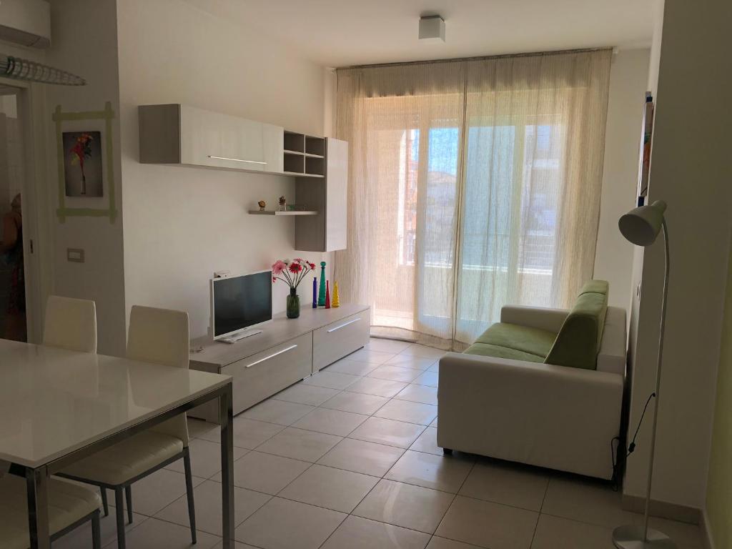 cocina y sala de estar con sofá y mesa en Le Miromí, en Civitanova Marche