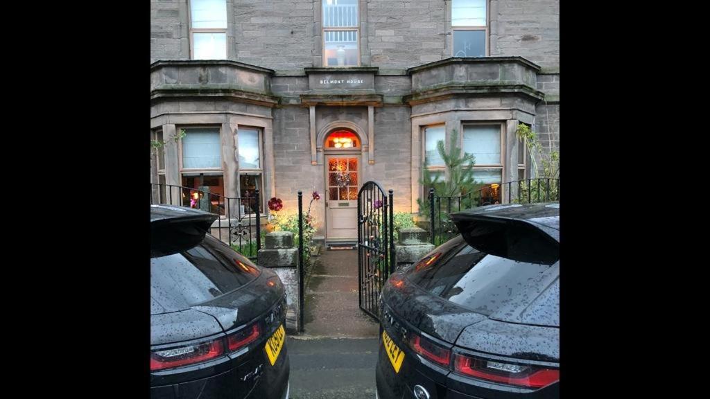 dwa samochody zaparkowane przed domem w obiekcie Belmont House Boutique - the Kingsley collection w mieście Berwick-upon-Tweed