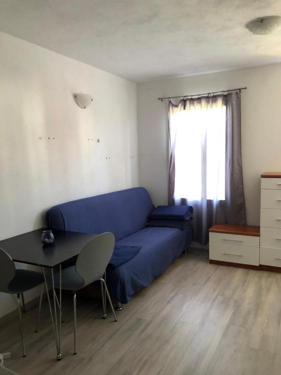 - un salon avec un canapé bleu et une table dans l'établissement Lily 7, à Koper