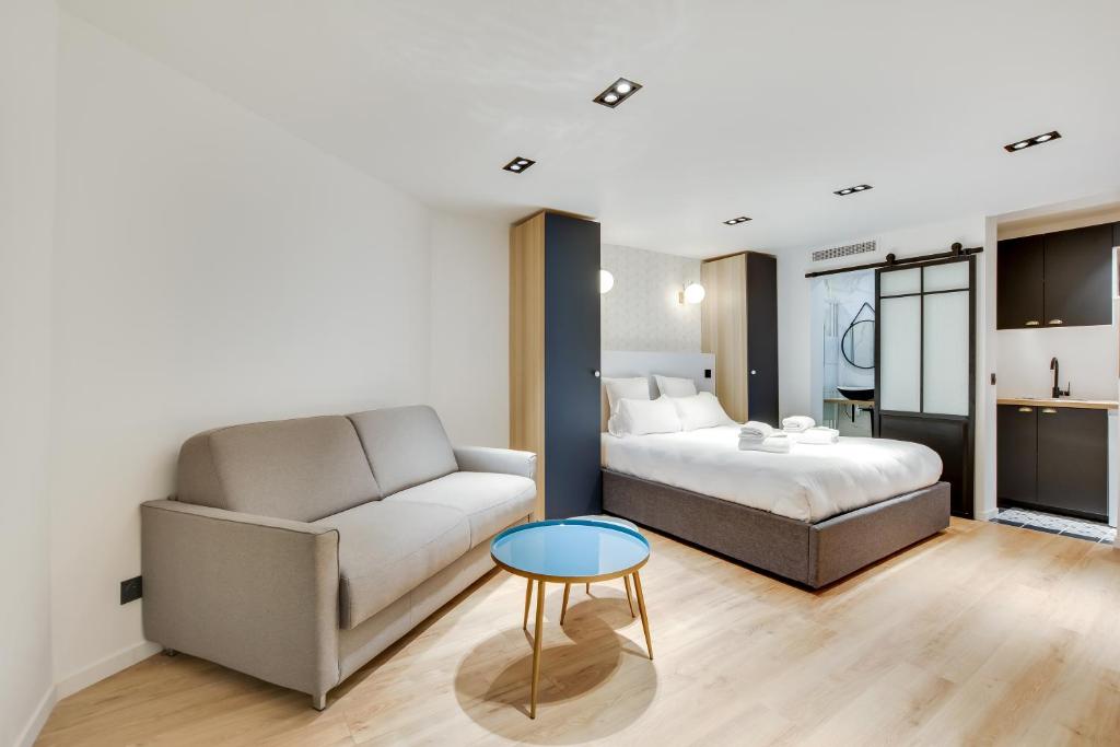 - une chambre avec un lit, un canapé et une table dans l'établissement Pick A Flat's Apartment in Bastille - Rue du Chemin Vert, à Paris