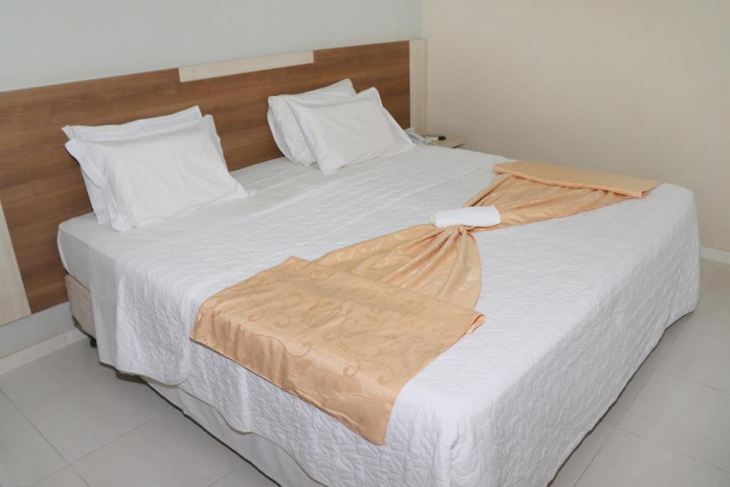 um quarto com uma cama grande e lençóis brancos em Solar das Mangueiras em Barreiras