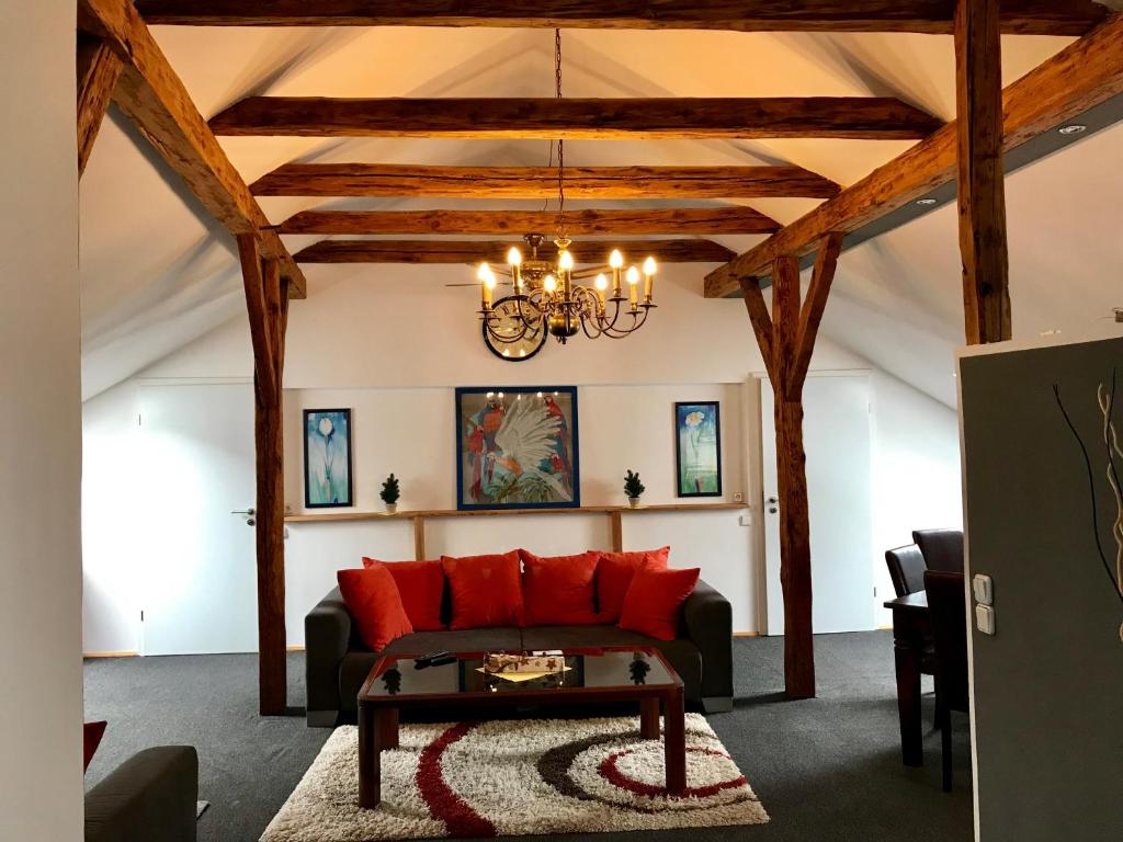 sala de estar con sofá rojo y lámpara de araña en Historic Apartments, en Vegesack