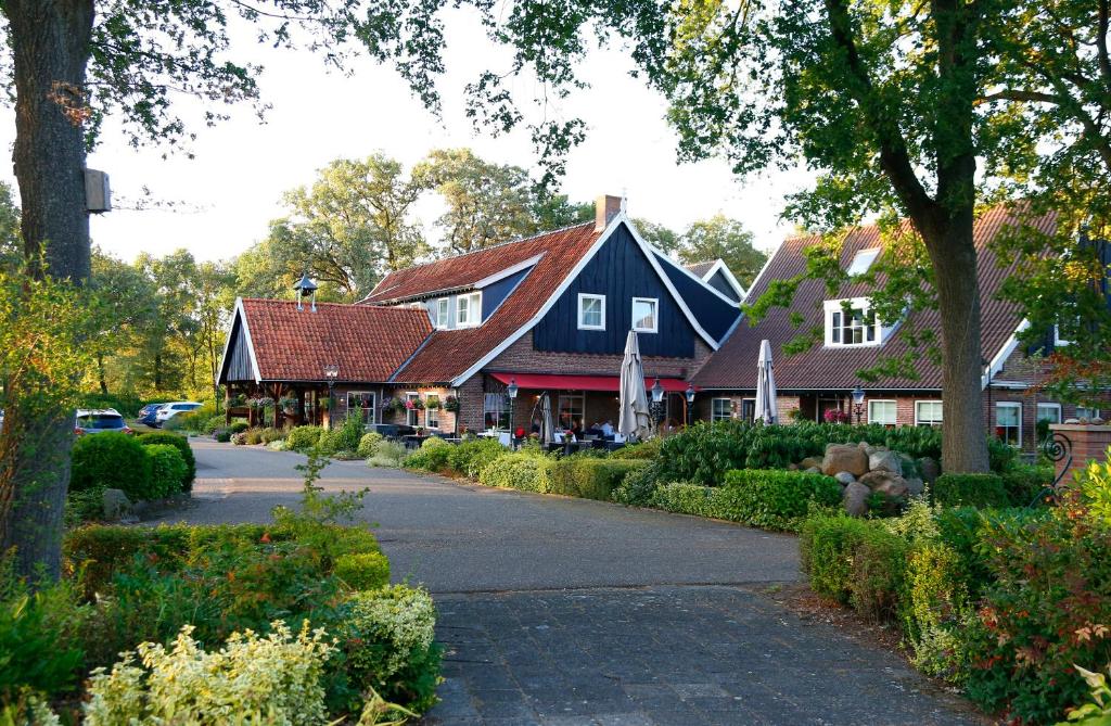 uma casa com um telhado azul e vermelho em Het Ros van Twente em De Lutte