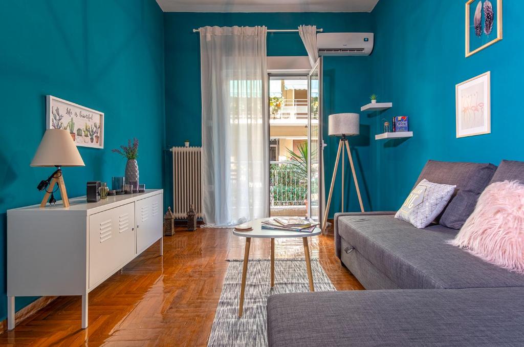 a blue living room with a couch and a table at Colourful apt,airport line,6 min metro,100 MBPS! in Athens