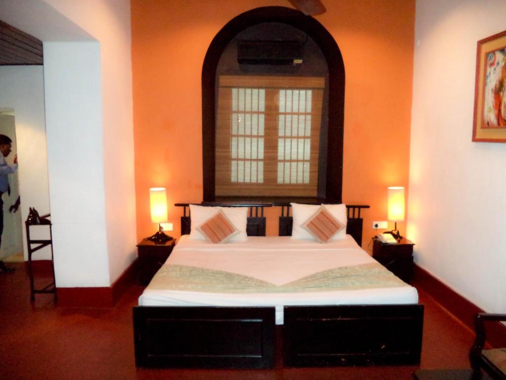 a bedroom with a large bed with two lamps at The Heritage Ambepussa in Ambepussa