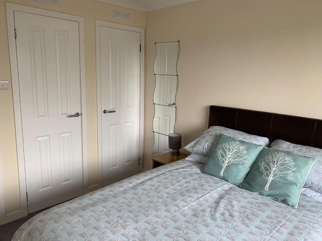 a bedroom with a bed with two pillows on it at 10 Redcliffe in Stornoway