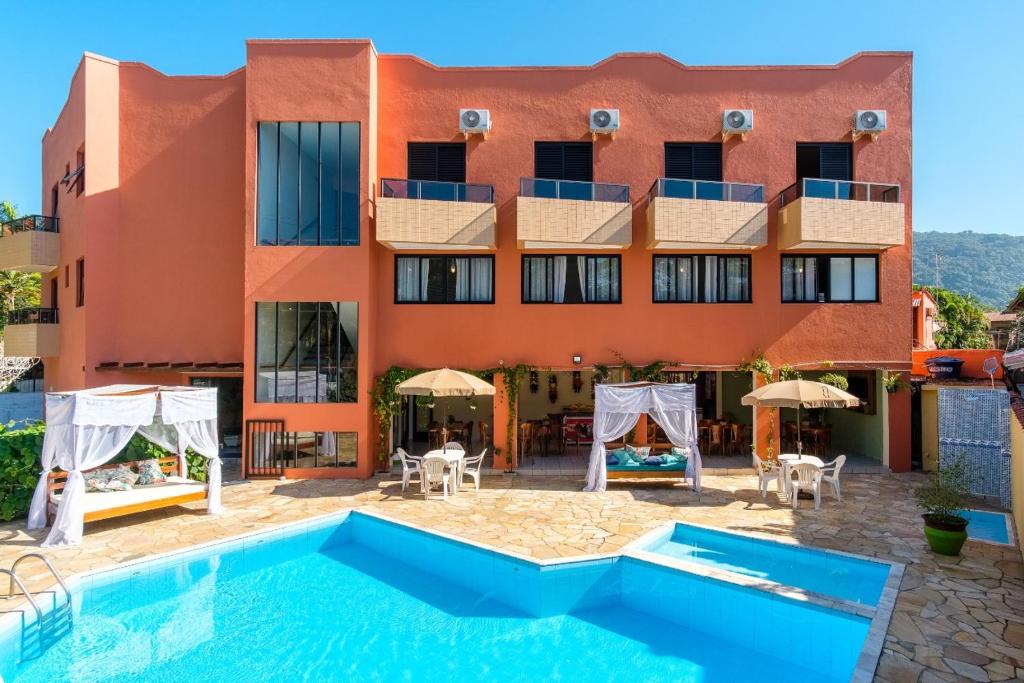 um hotel com piscina em frente a um edifício em Hotel Ponta das Toninhas em Ubatuba