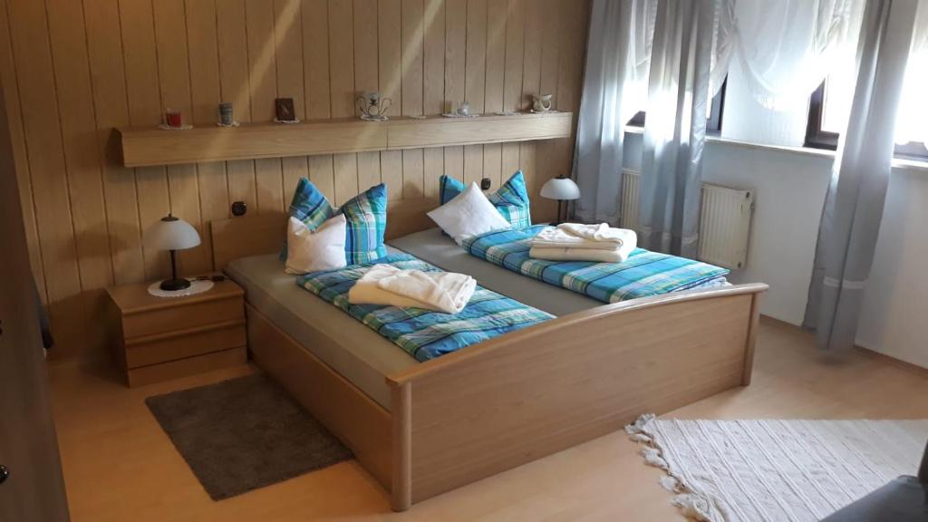 1 Schlafzimmer mit 2 Betten mit blauen und weißen Kissen in der Unterkunft Ferienwohnung Dippold in der fränkischen Schweiz in Heiligenstadt