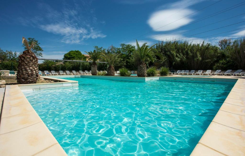 - une piscine d'eau bleue dans un complexe dans l'établissement SOWELL RESIDENCES Les Mazets, à Arles