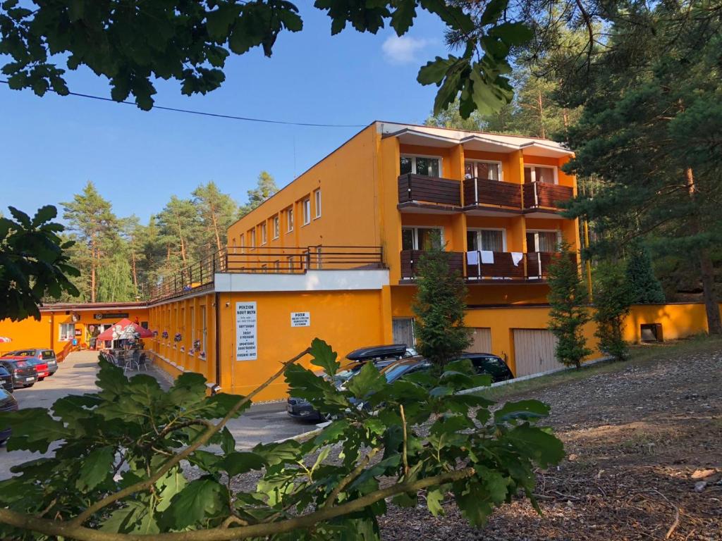 un edificio arancione con macchine parcheggiate di fronte di Penzion Nový mlýn a Staré Splavy