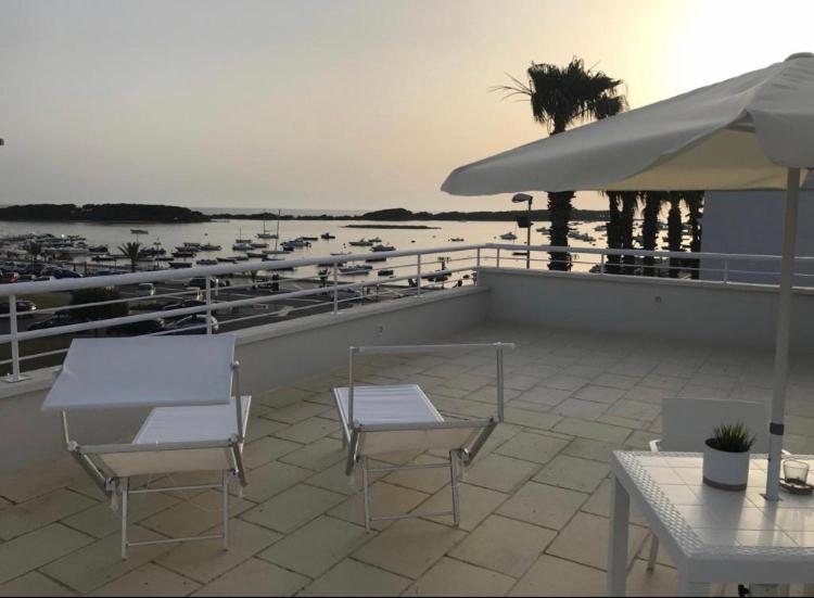 un patio con mesas y sillas y vistas al puerto deportivo en Camera sul mare Riviera, en Porto Cesareo