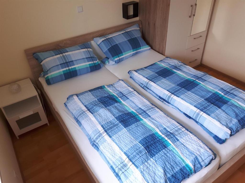 a bedroom with two beds with plaid pillows at Ferienwohnung Nicole in Isny im Allgäu